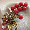 Dark pink glass pearls (5.5 mm) and Austrian crystals with an enamel leaf and ribbon accent design

49x33 mm

Silver plated